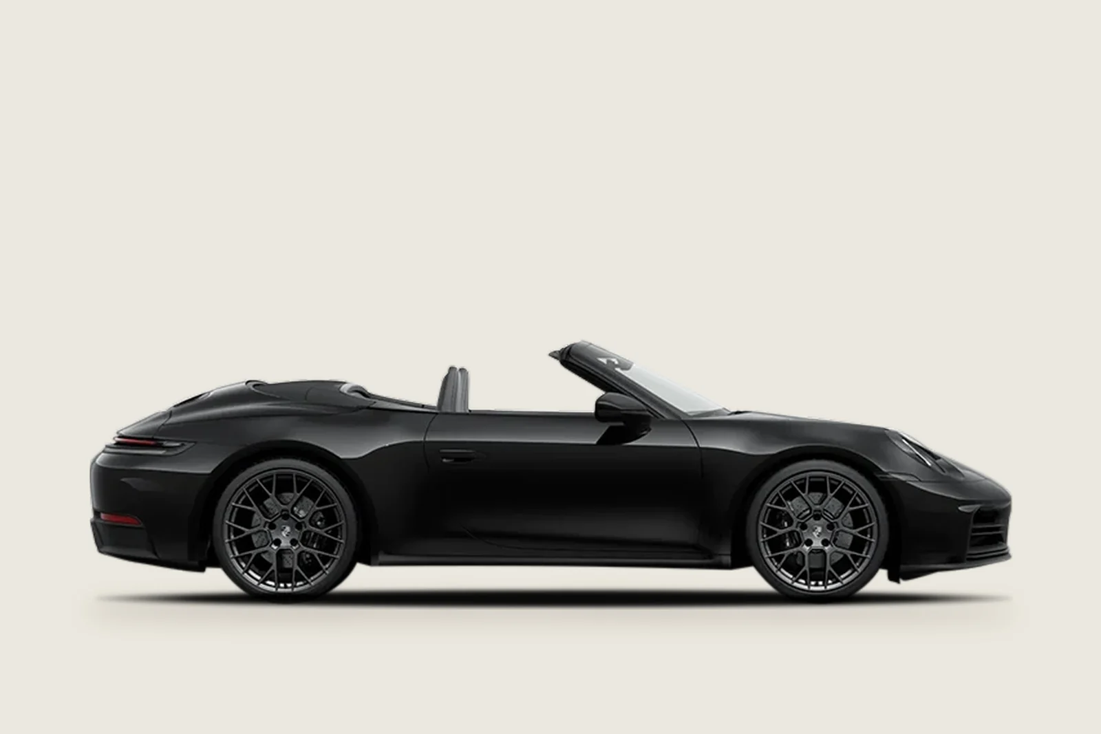 Black Porsche 911 Carrera 4 GTS Cabriolet with the roof down seen from the side